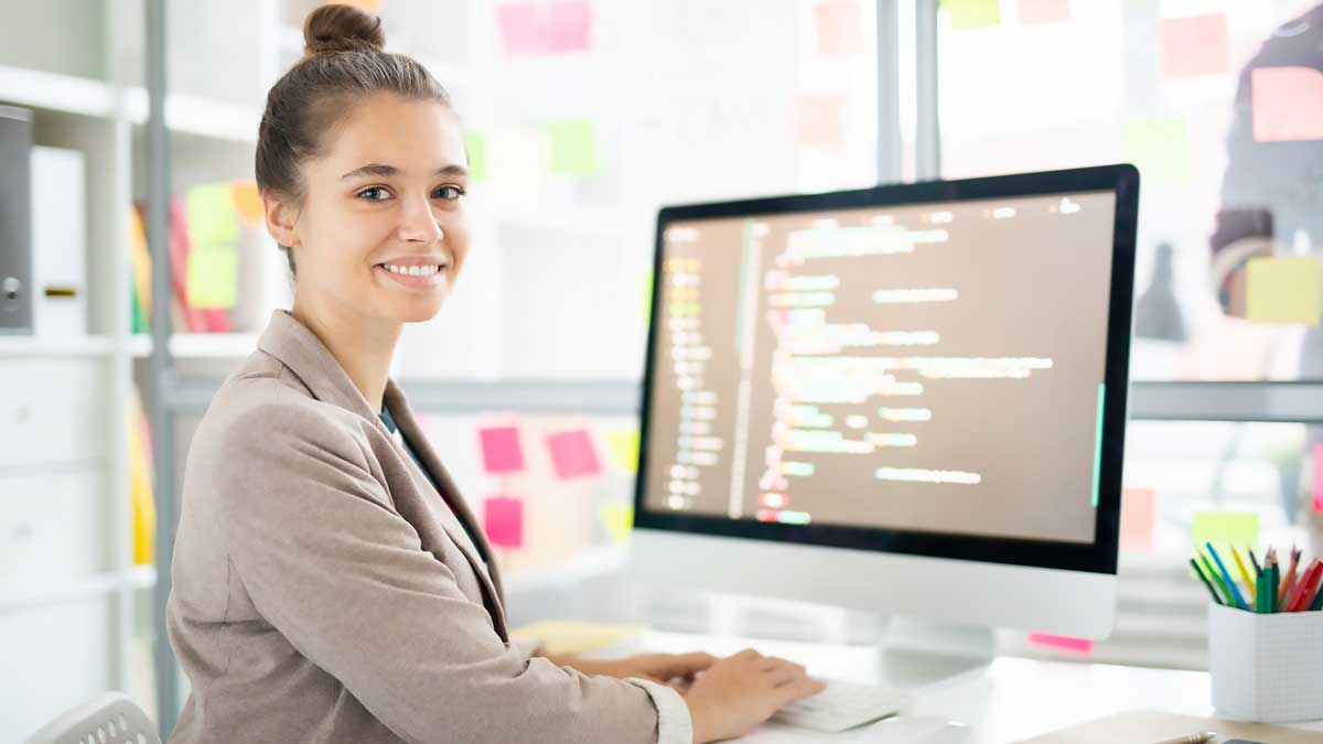 Una giovane donna programmatrice seduta davanti al proprio pc.